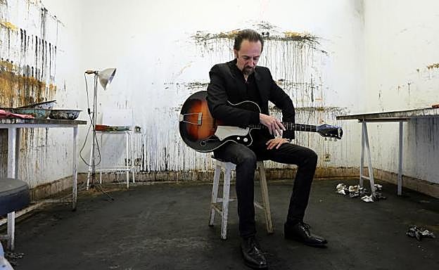 Diego Vasallo en su estudio, con la guitarra antigua que compró en los primeros tiempos de Duncan Dhu