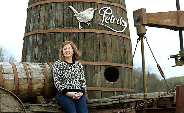 Ainara Otaño, quinta generación al frente de Petritegi, posa junto a una enorme 'kupela' junto al negocio familiar.