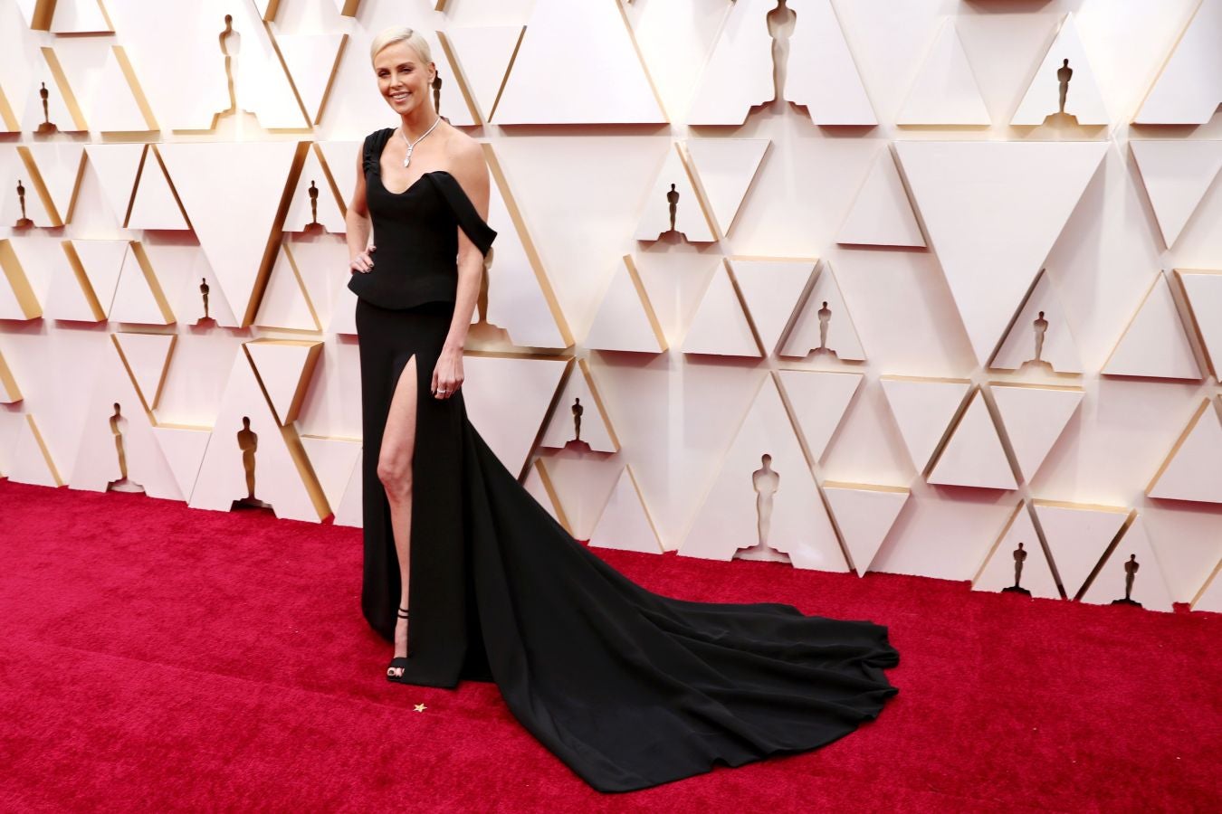 Charlize Theron no ha defraudado y también de Dior, ha cautivado con un vestido negro asimétrico con cola e impactante abertura en la pierna izquierda, un espectacular collar, maquillaje efecto “cara lavada” y el pelo recogido con el clásico moño de bailarina