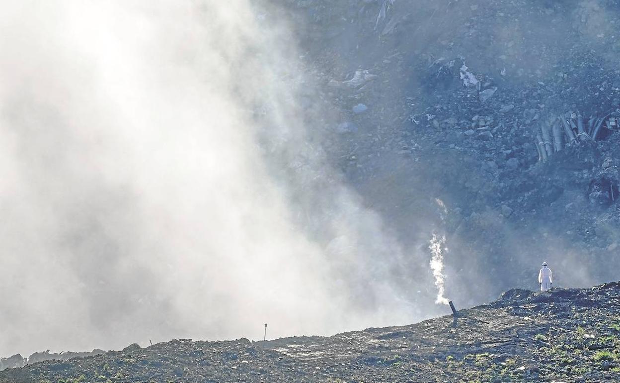 Un operario trabaja en el vertedero de Zaldibar, del que ayer salía un humo intenso, fruto de la combustión de clorados y plásticos, lo que provoca la emisión de dioxinas. 