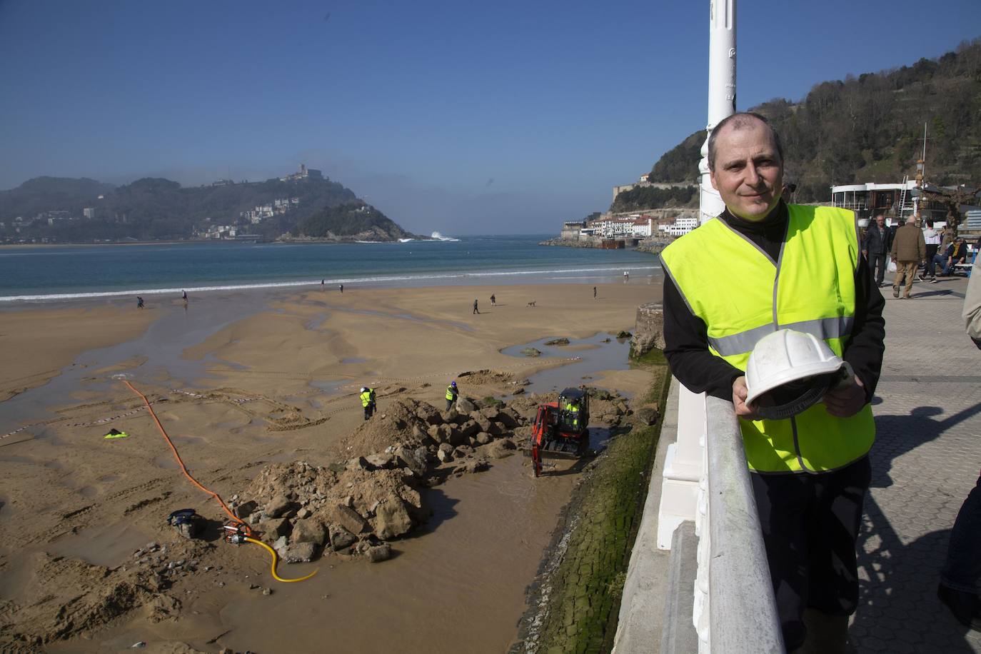 La playa de La Concha se ha convertido en la bajamar de este lunes por la mañana en un inesperado yacimiento arqueológico. La presencia de una pequeña excavadora retirando piedras y escombros junto al muro de costa a la altura del edificio consistorial ha suscitado una gran expectación entre los numerosos viandantes y turistas que han provechado el buen tiempo para dar un paseo. La máquina profundizaba en la arena en busca de los restos de un barco hundido del que hay constancia documental desde el siglo XVIII. 
