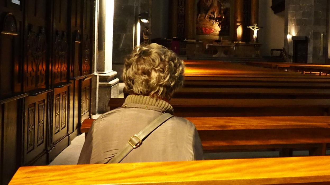 Una mujer reza en solitario en la parroquia de San Bartolomé, ayer por la mañana. 