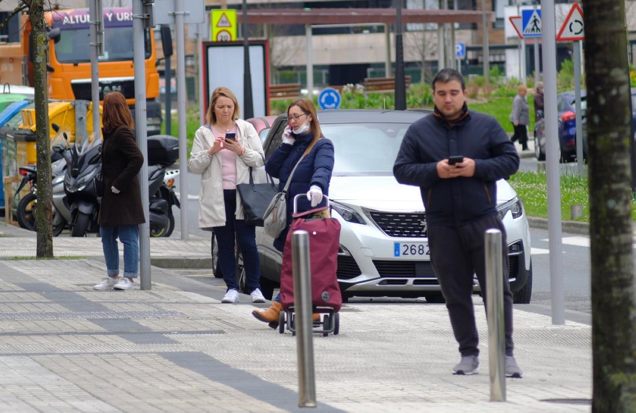 Ciudadanos hacen cola, manteniendo la distancia de seguridad, para acceder a una panadería. 