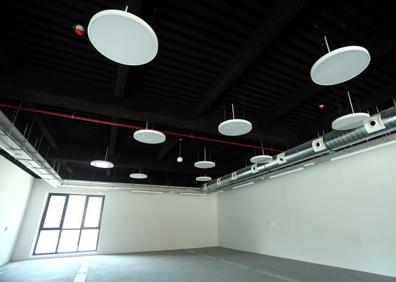 Imagen secundaria 1 - Vista exterior del edificio, una de las salas que acogerá la biblioteca y detalle de las escaleras que rodean uno de los laterales, una de las señas de identidad de la antigua panificadora.