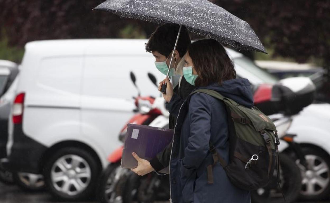 Dos jóvenes caminan con la mascarilla puesta cerca del Hospital Universitario Donostia. 