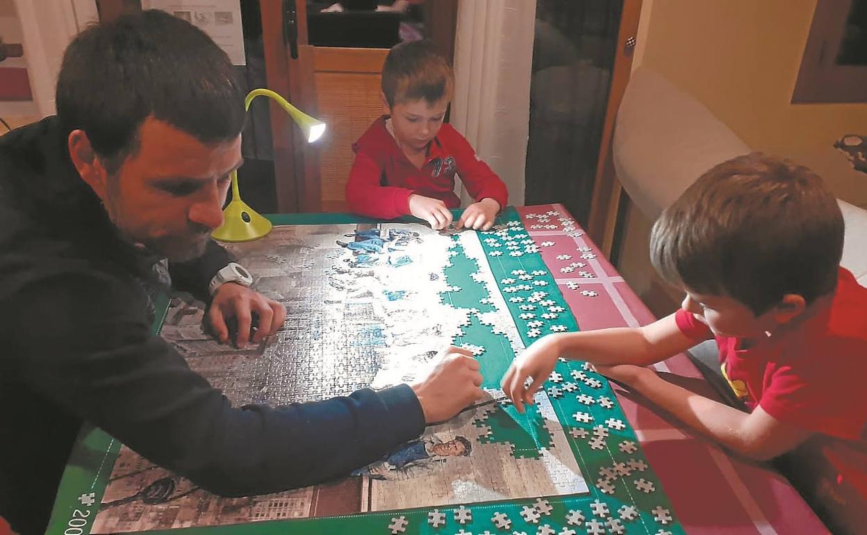 Jon Altuna completa un puzzle en su domicilio junto a sus dos hijos.