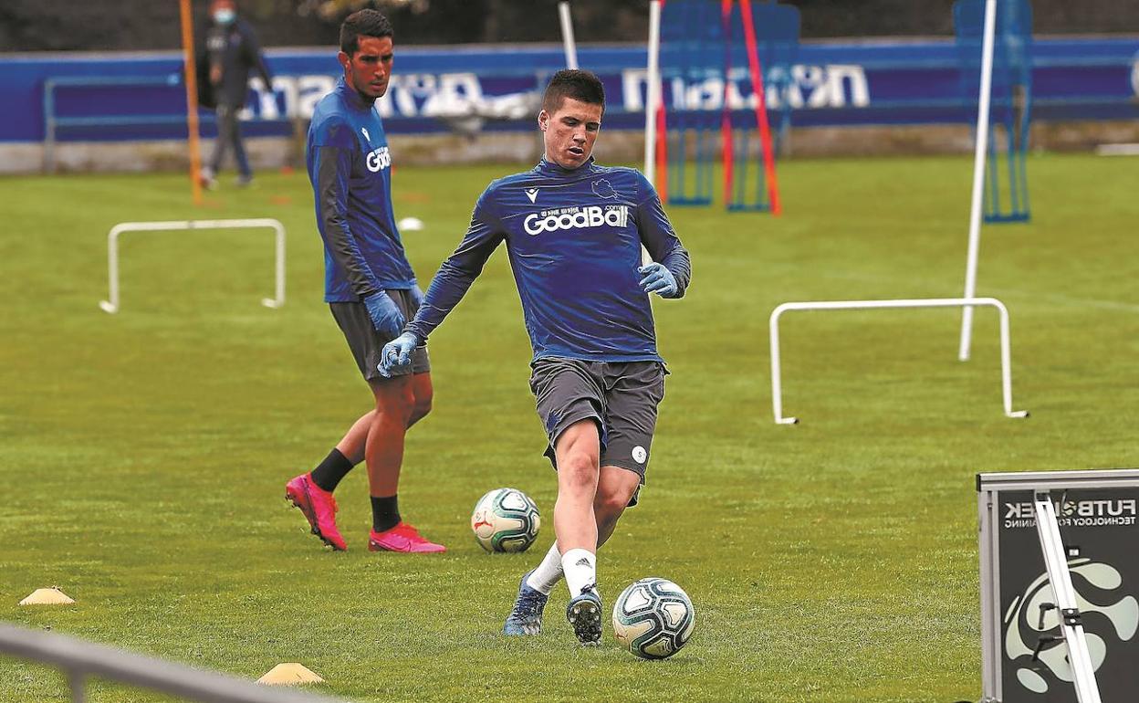 Zubeldia ejecuta un golpeo en un entrenamiento en Zubieta con el joven Roberto López a su espalda. 