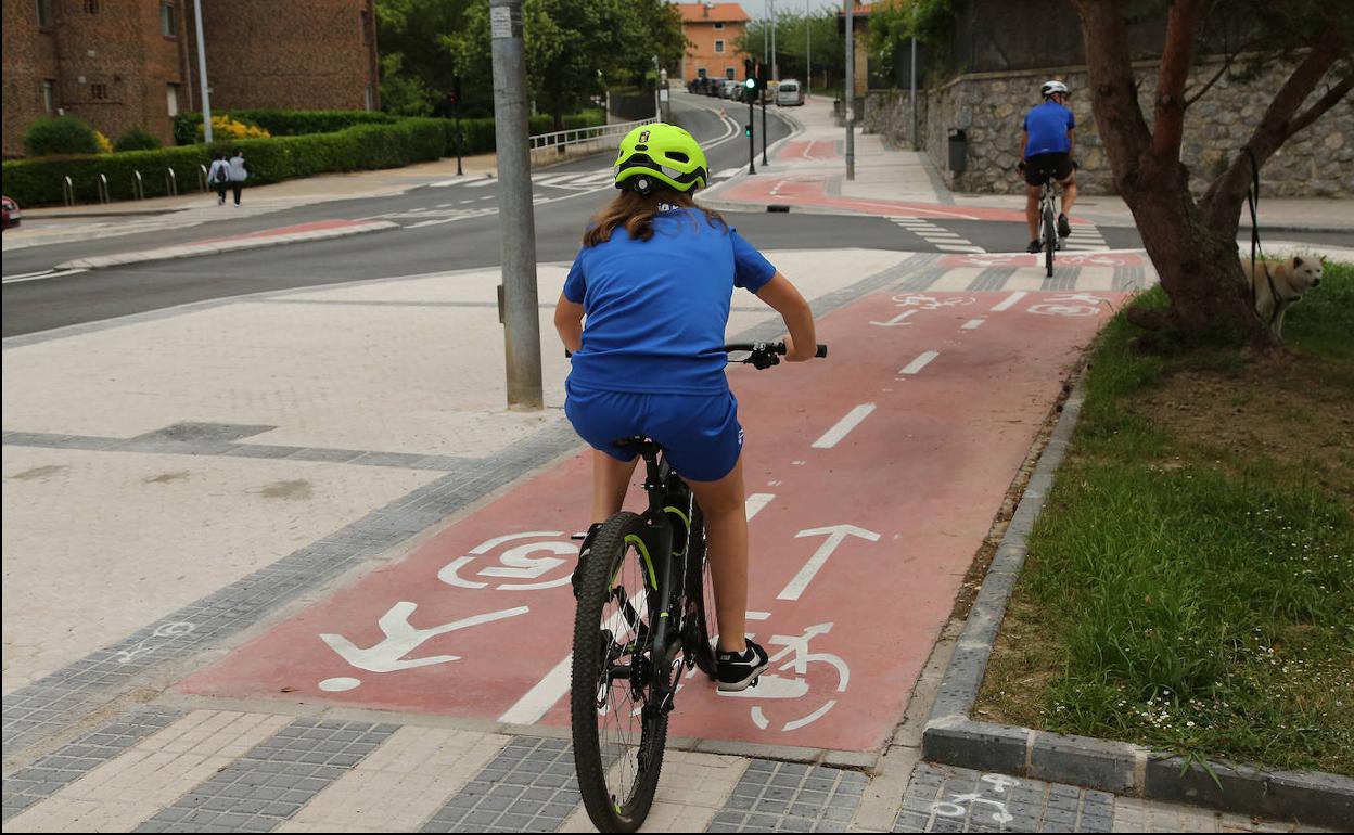 Dos ciclistas se dirigen hacia el Jolastoki, tras pasar por Munto, en el nuevo bidegorri. 