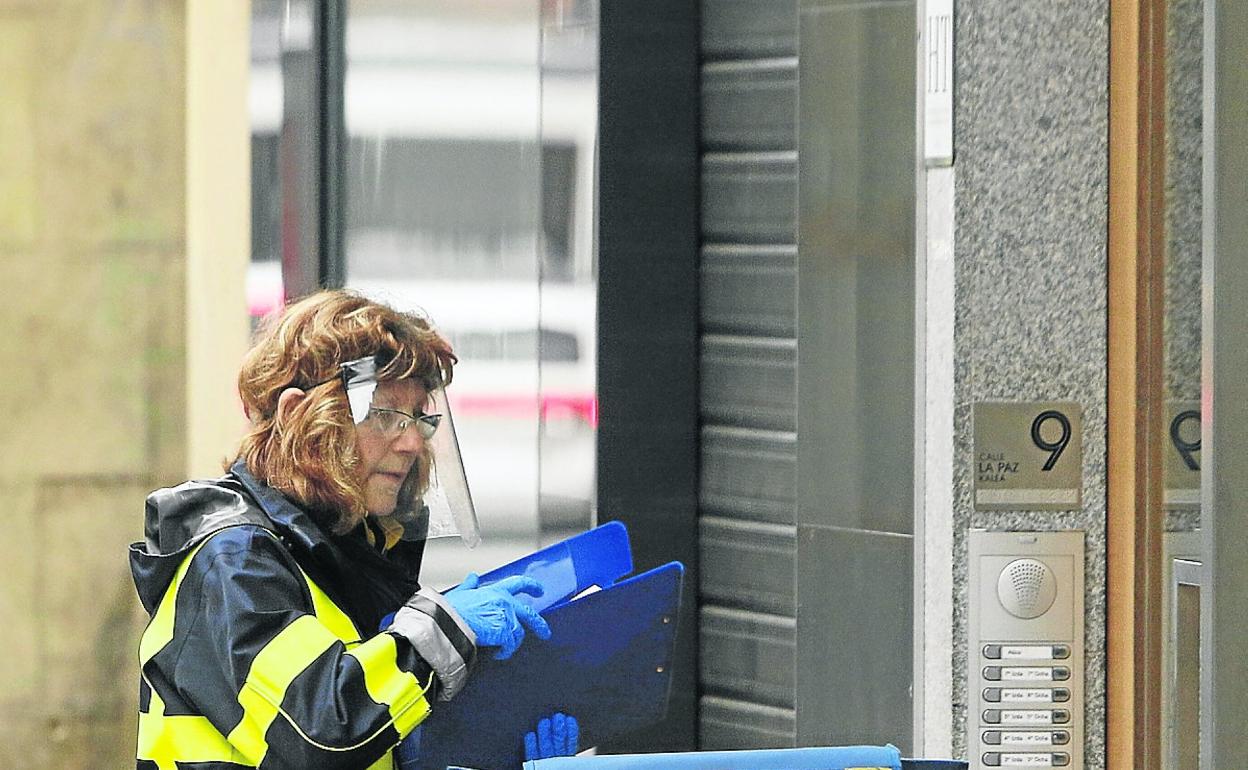 Una cartera, con pantalla protectora y guantes, durante un reparto en el centro de Vitoria. 