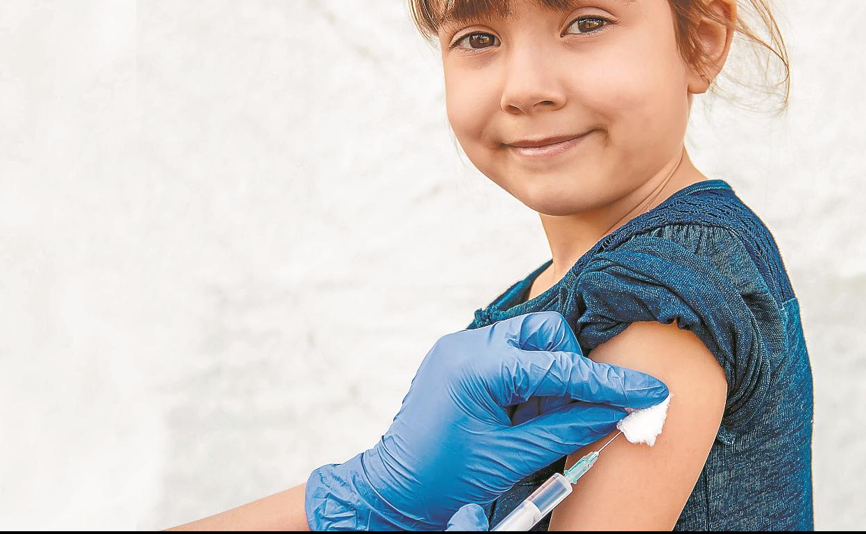 Una niña recibe la inyección de una vacuna en el brazo.