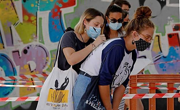 Varias jóvenes guardan cola para hacerse voluntariamente test de covid-19 en Barcelona.