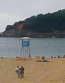 Imagen secundaria 2 - La playa de Ondarreta con bandera roja, la bahía vacía de embarcaciones y bañistas desde Igeldo y la patrullera de la Guardia Civil durante las labores de búsqueda.