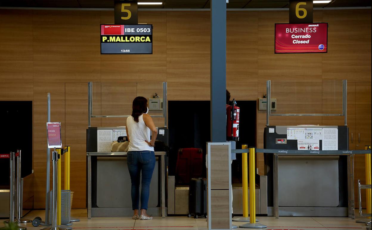 Una pasajera, en uno de los mostradores, para ir a Palma, uno de los vuelos estivales en agosto.