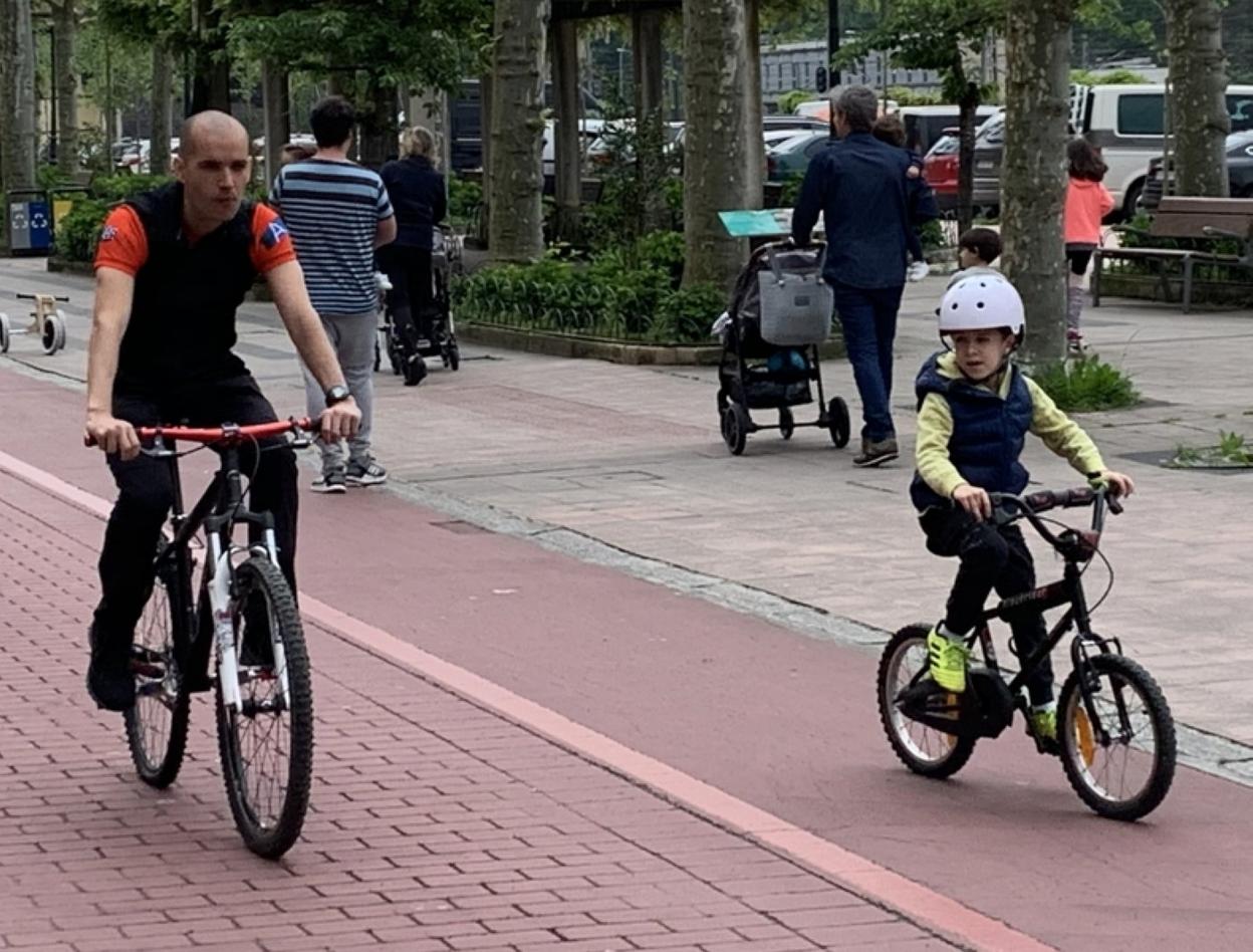Un padre y su hijo por el bidegorri en bicicleta. 