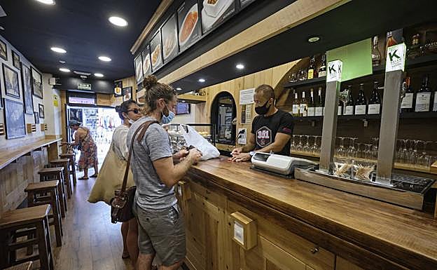 Javier Navarro atiende a dos turistas, que piden un bocadillo para llevar.