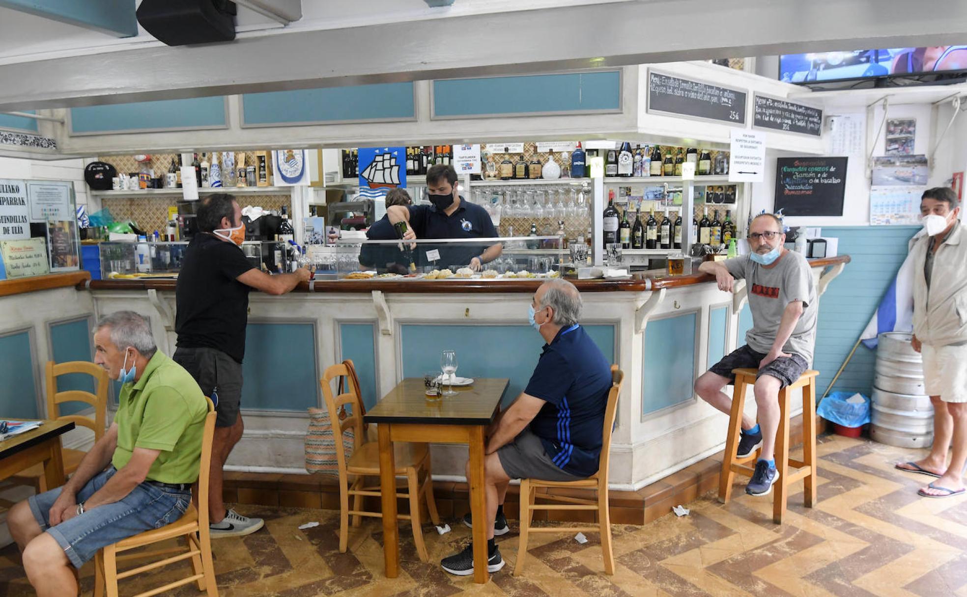 Clientes sentados en el bar Rikardo, donde la barra perdió su anterior función. 