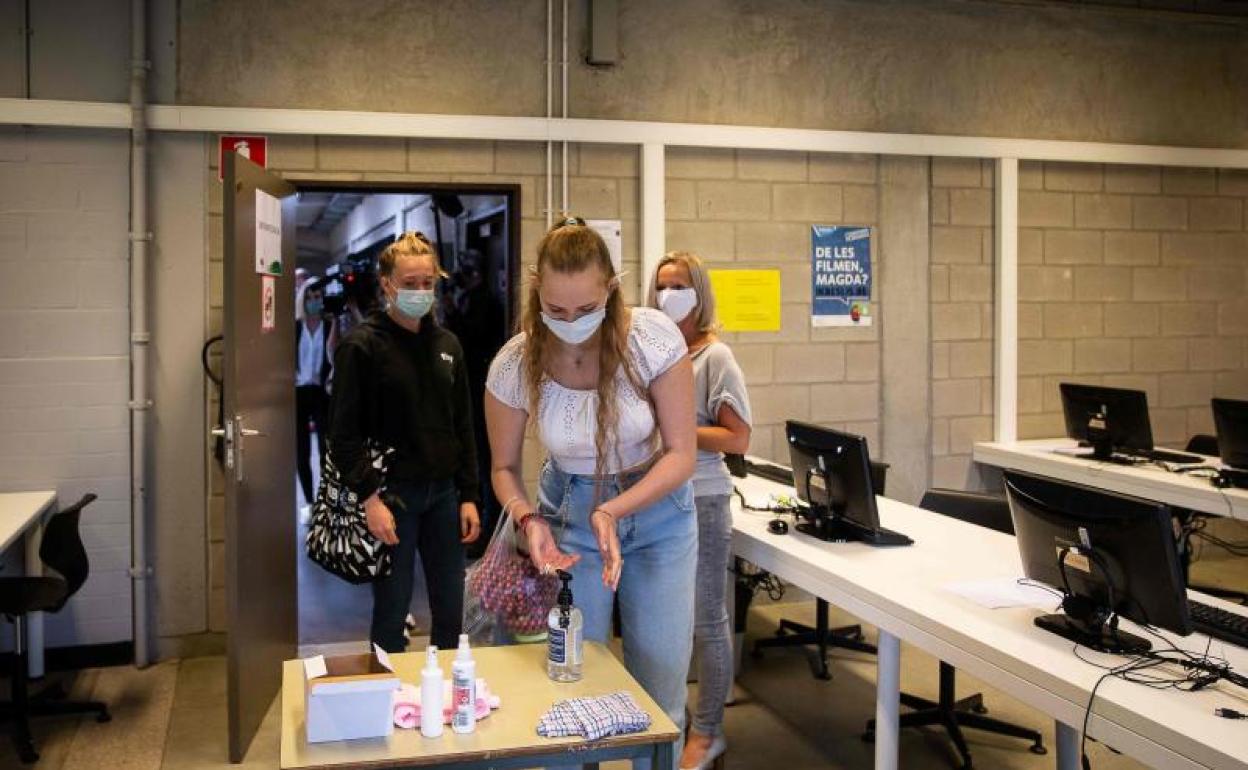 Alumnas de un colegio belga se desinfectan las manos antes de comenzar una clase