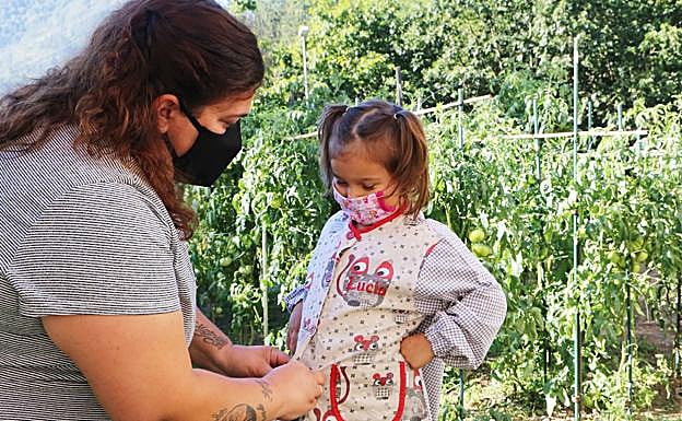 Ana prueba la bata y la mascarilla a su hija Lucía. 
