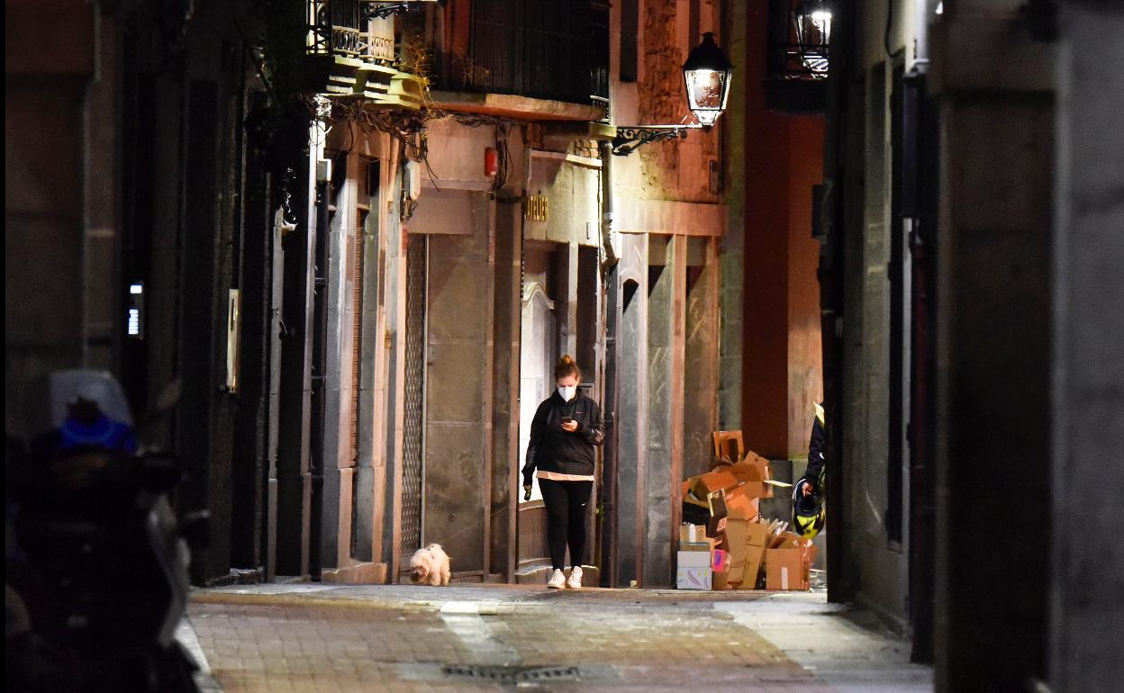 Una mujer ayer al anochecer pasea a su perro por la calle Letxuga de Tolosa.