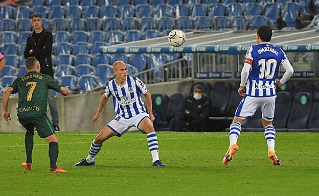 Guridi y Oyarzabal intentan hacerse con el control del balón en el centro del campo anoche durante el partido en el Reale Arena. 