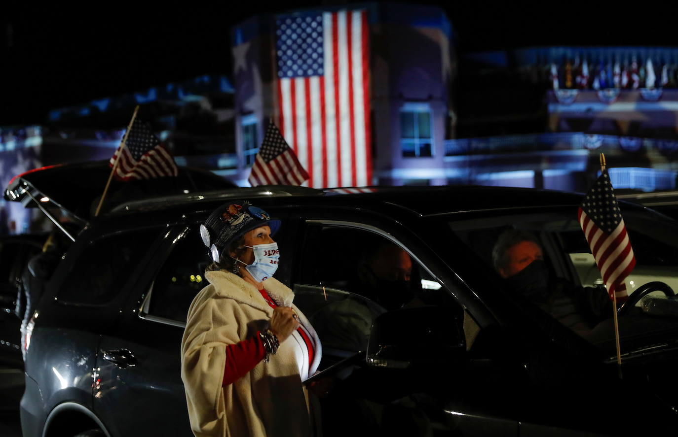 Lydia Massey, de Dover, Delaware, está al lado de su vehículo viendo los resultados de la votación.