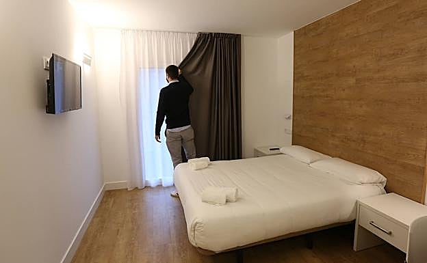 Alejo Ibeas cierra la cortina de una de las habitaciones del hotel Ondarreta Beach. 