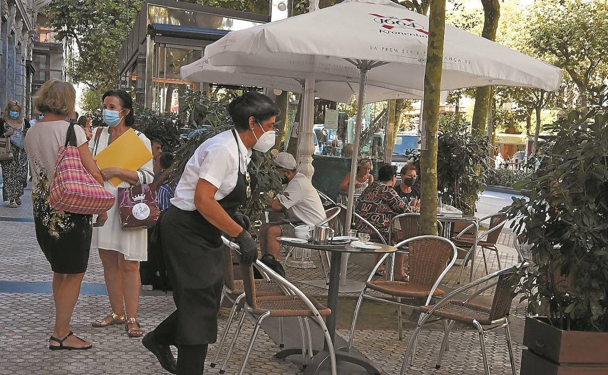 Una empleada sirve en una cafetería del centro de San Sebastián. La hostelería es uno de los sectores más golpeados por el Covid.