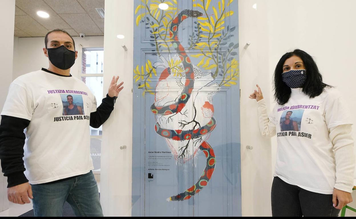 Juanjo y Yoana Niebla, hermanos de Asier, posan junto a la puerta dedicada al joven, en la casa de cultura de Urnieta.