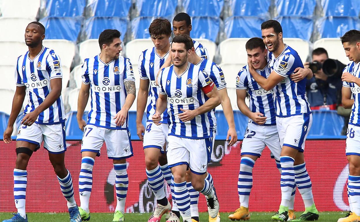 Merino felicita a Barrenetxea por su golmientras el resto de compañeros vuelvehacia su sitio tras celebrarlo