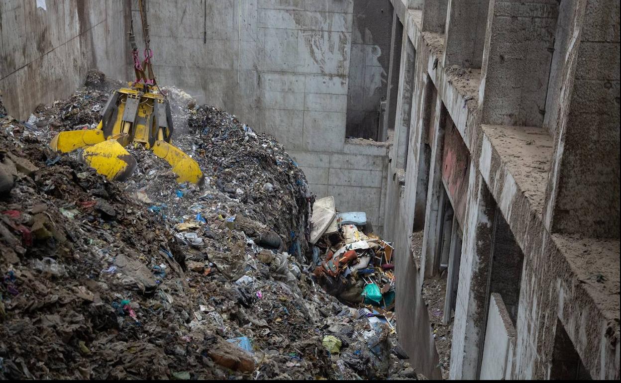 Un pulpo mecánico coge basura para echarla a los hornos donde se queman los residuos en la incineradora de Zubieta.