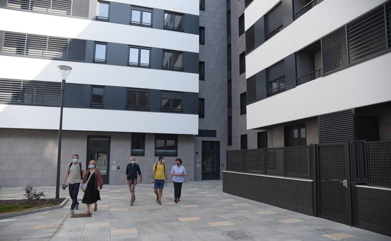  Varias personas pasean ante las viviendas del alquiler VPO en el barrio donostiarra de Txomin Enea. 