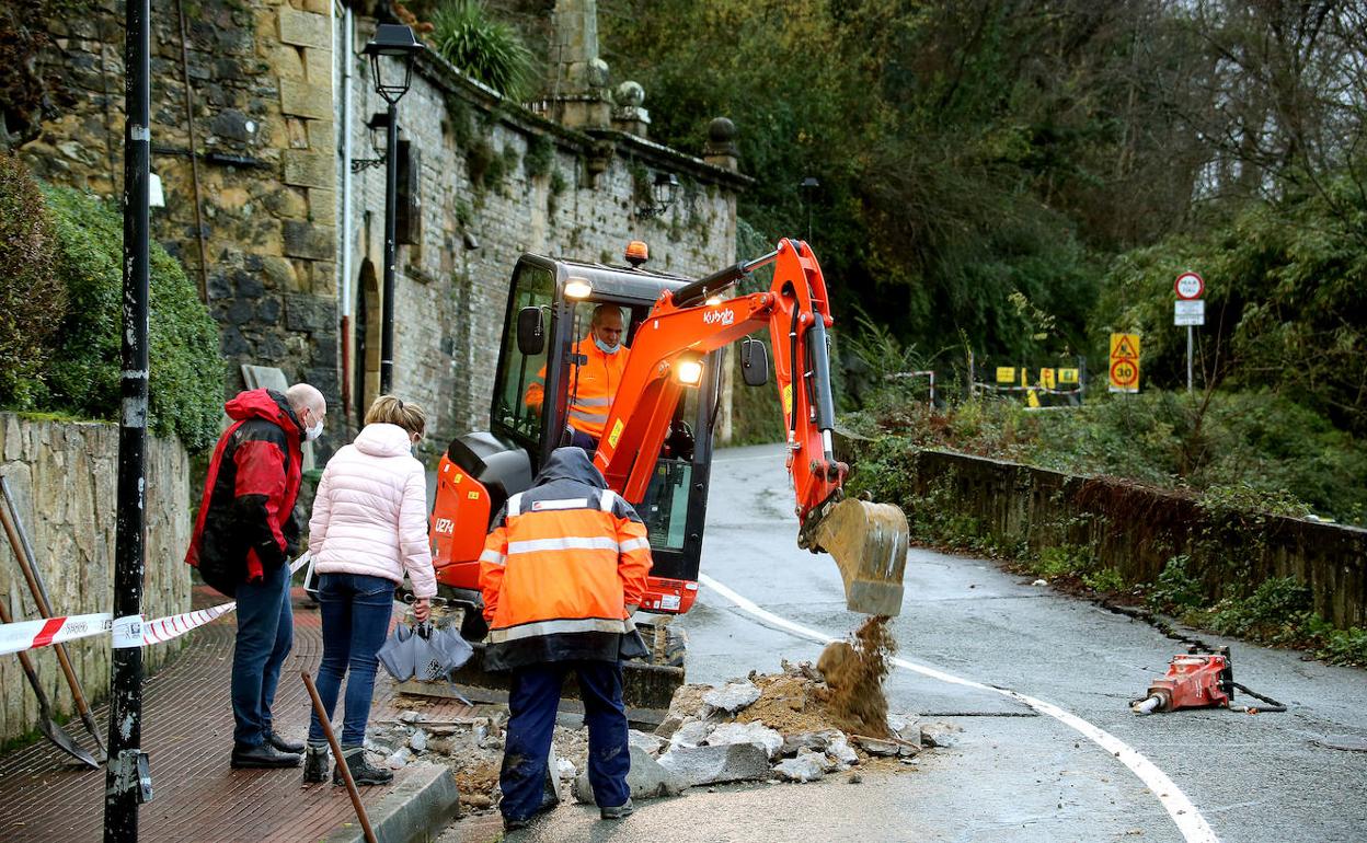 Los técnicos intentan devolver el suministro de agua a viviendas del Paseo del Faro, en cuya calzada, a la derecha, se observan las grietas