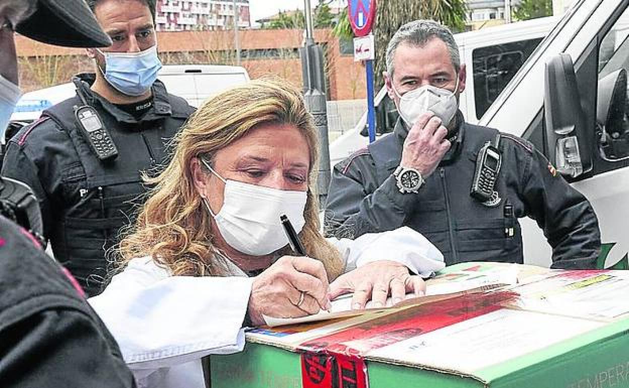 La consejera, firmando el albarán de recepción de un lote de vacunas. 