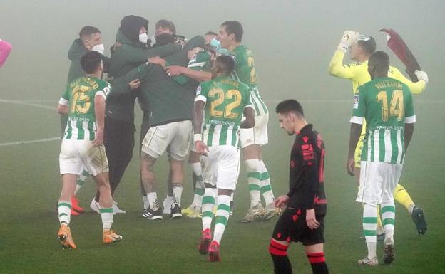 Los jugadores del Betis celebran un gol mientras Imanol arenga a sus jugadores en los minutos previos al inicio de la prórroga, ayer en Sevilla. 