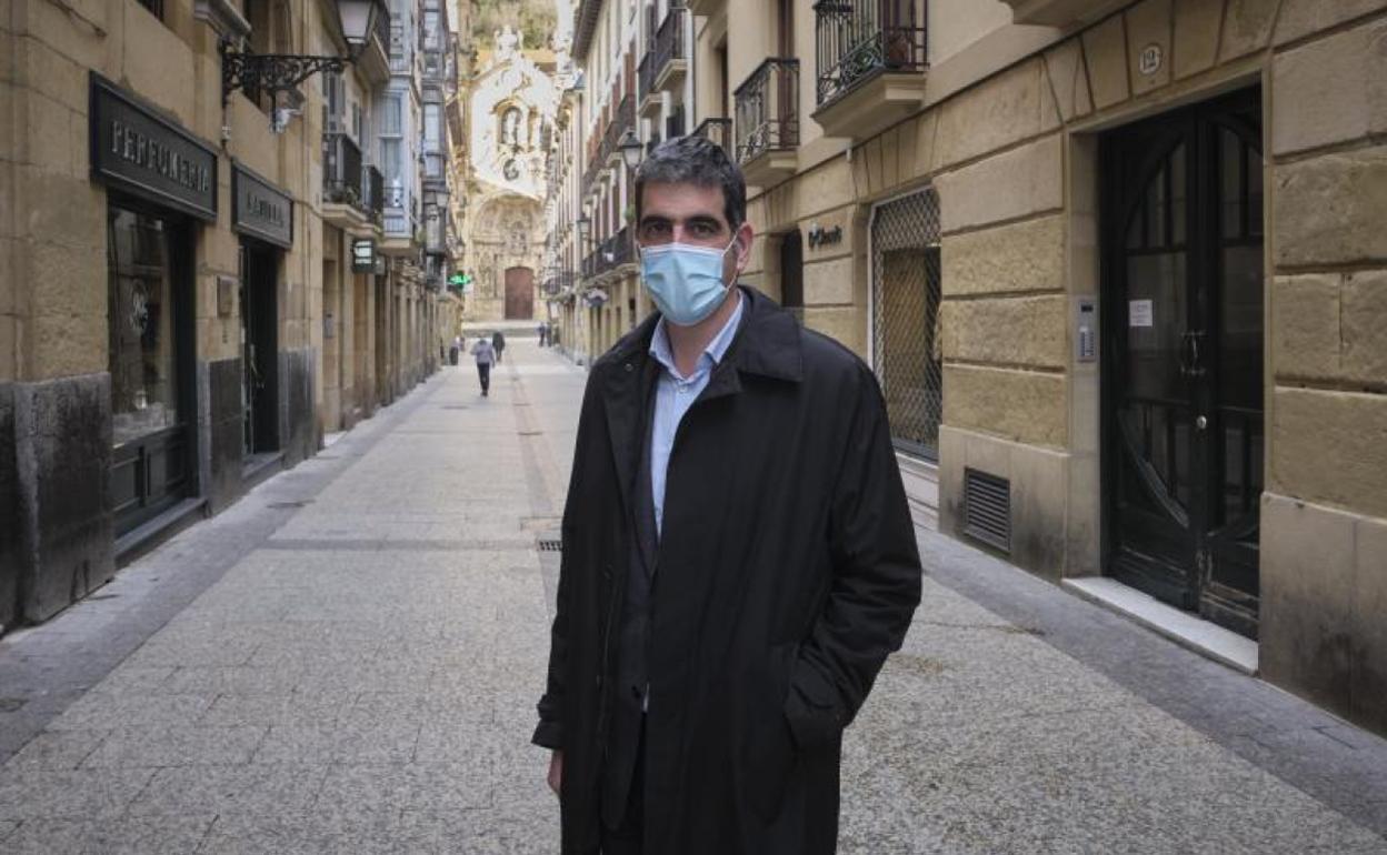 El alcalde de Donostia, Eneko Goia, posa en la calle Mayor, prácticamente vacía, de la Parte Vieja de San Sebastián. 