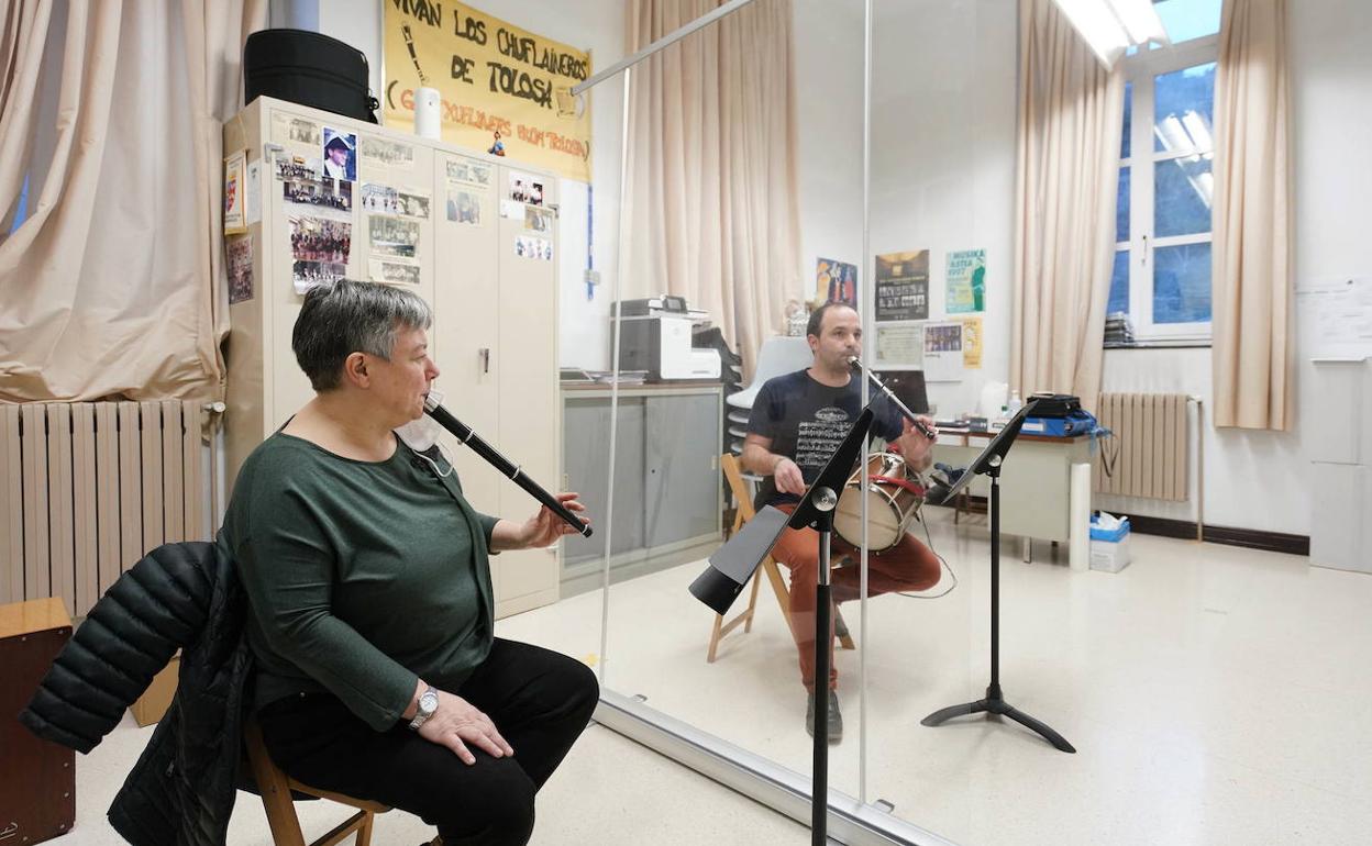 Una profesora de Tolosa y su alumno dan clase separados por una mampara. 