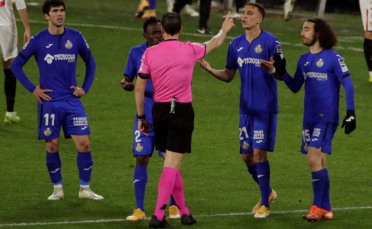 Martínez Munuera señala el camino a los vestuarios a Djené tras expulsarle en el Sánchez Pizjuán.