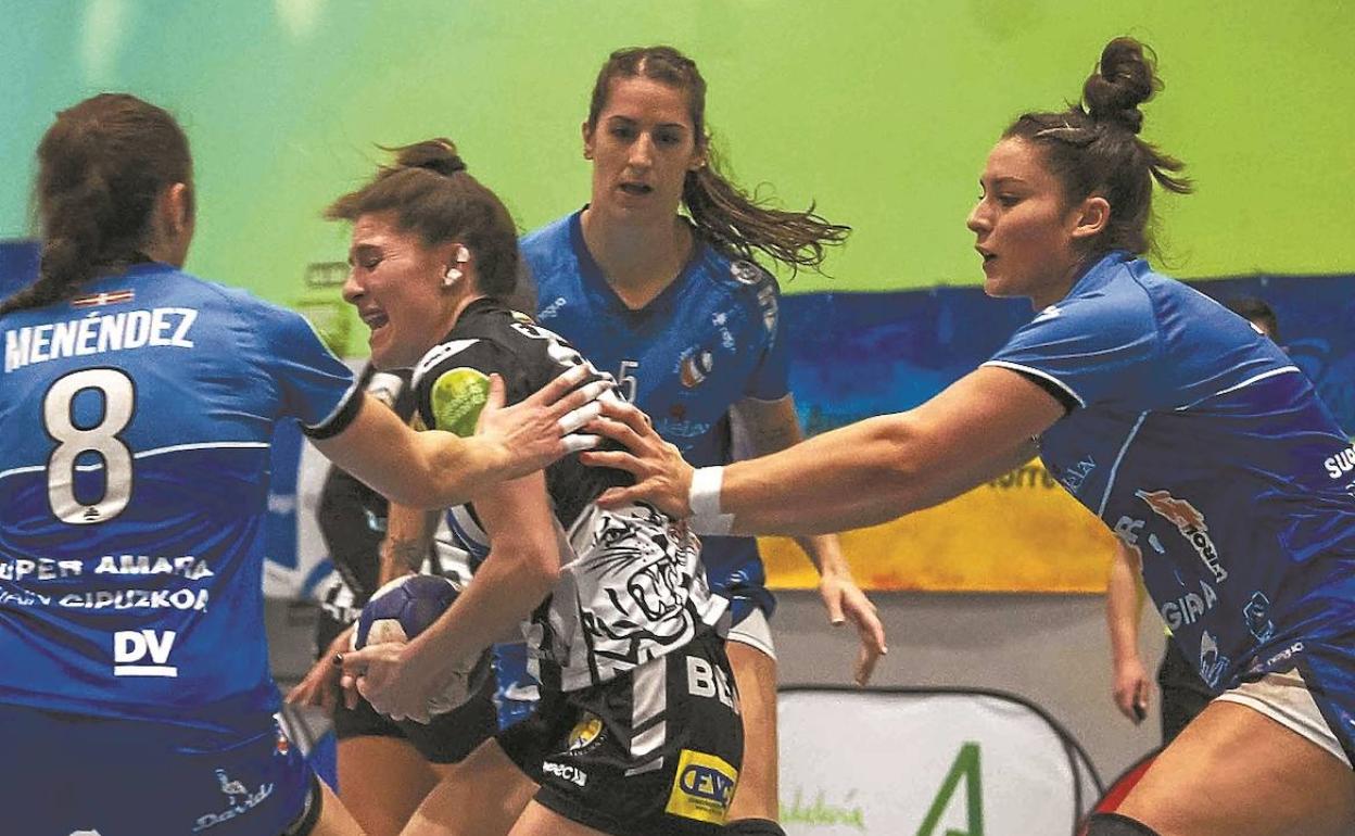 Menéndez y Cesáreo, en el bloque defensivo central, impiden la circulación de una jugadora rival durante el partido en Málaga. 