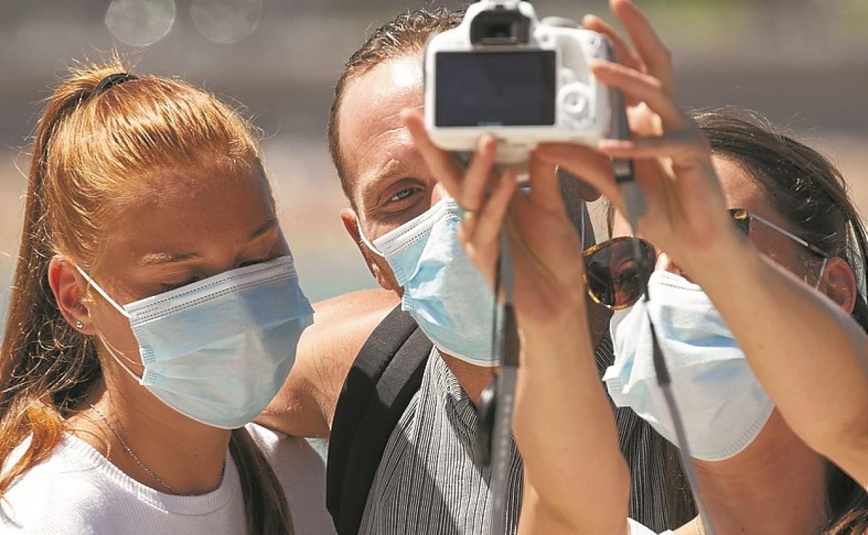 Varias personas se sacan una foto con la mascarilla puesta. michelena