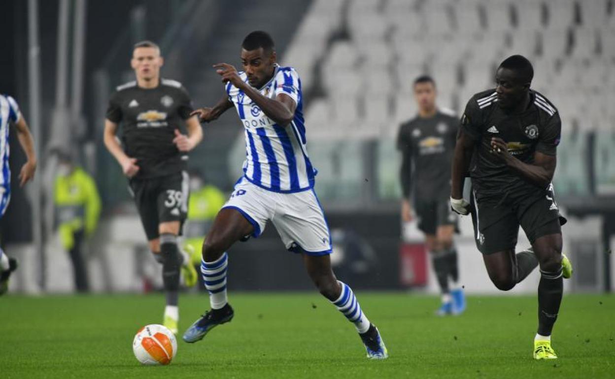 El delantero de la Real Sociedad Alexander Isak trata de escaparse de un defensor del Manchester United.