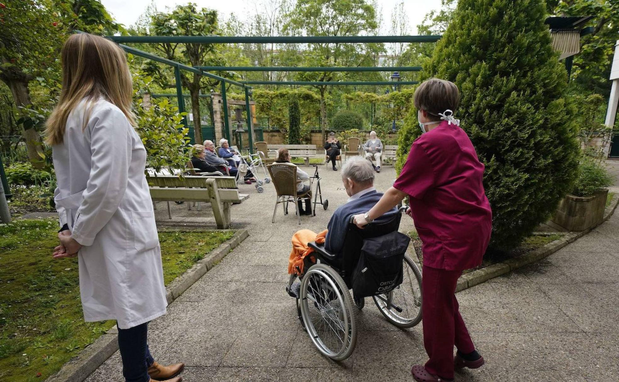 Usuarios de la residencia Sagrado Corazón de Errenteria aprovechan su momento en el jardín para socializar con sus compañeros. 