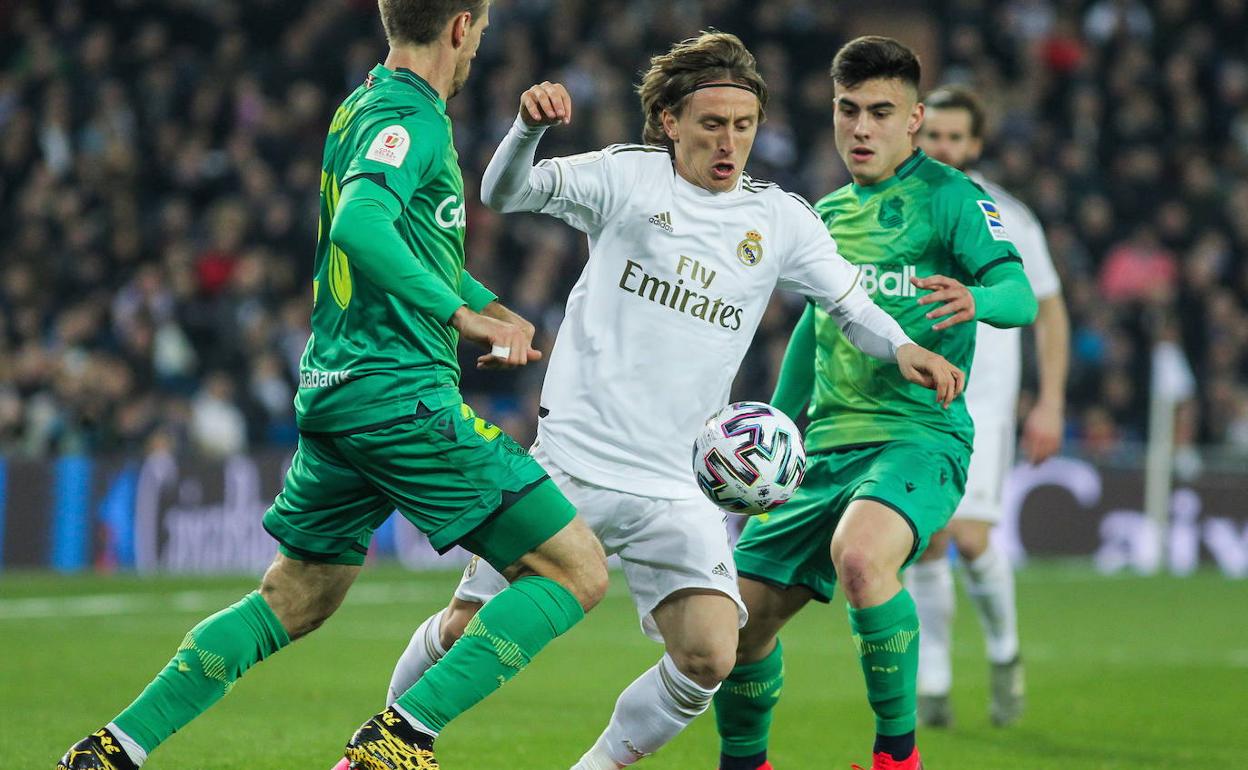 Monreal y Barrenetxea acosan a Modric por una pelota.