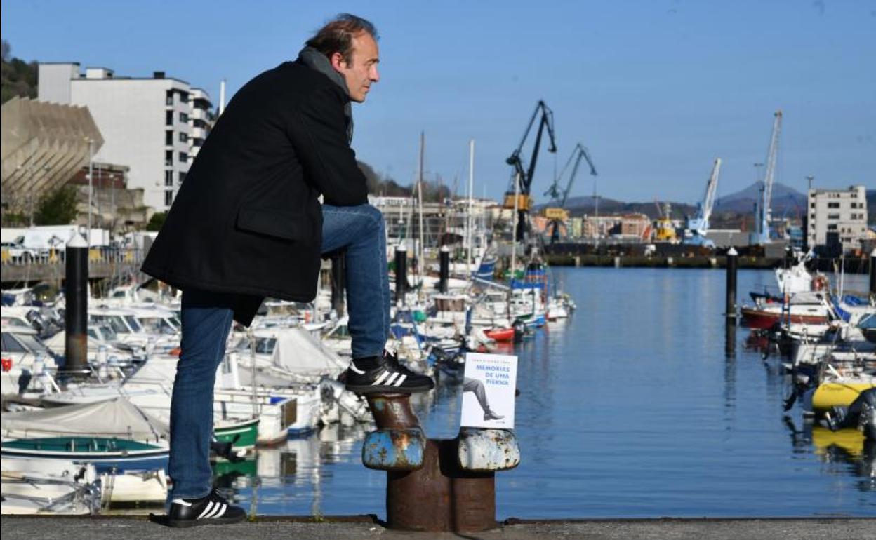 Roberto Álvarez Chans, con un ejemplar de su primera novela en el puerto de Pasaia. 