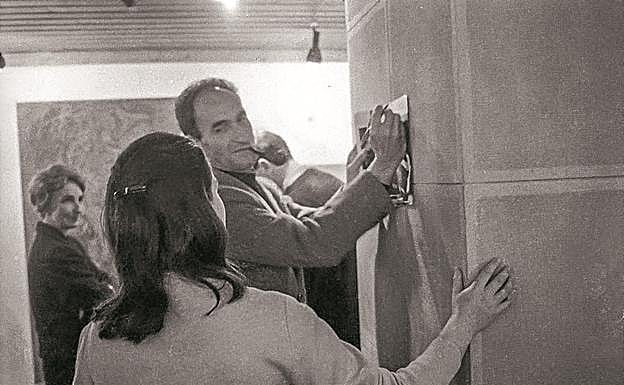 Imagen principal - Chillida, firma el catálogo a una visitante de la exposición. A la izquierda, Pilar Belzunce. El pintor Carlos Sanz, ante la obra 'Figuras incoscientes/Abrazo', de Oteiza. Juan Pablo Huércanos, autor del libro sobre el grupo Gaur