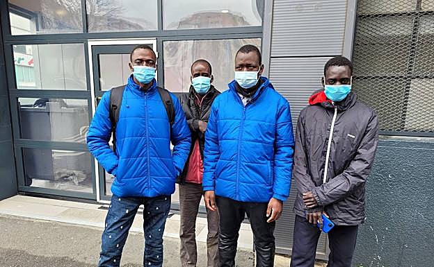 Imagen principal - Mohamed, Magasi e Ilo, todos de Malí. Miembros de Cruz Roja atienden a los migrantes en Irun.