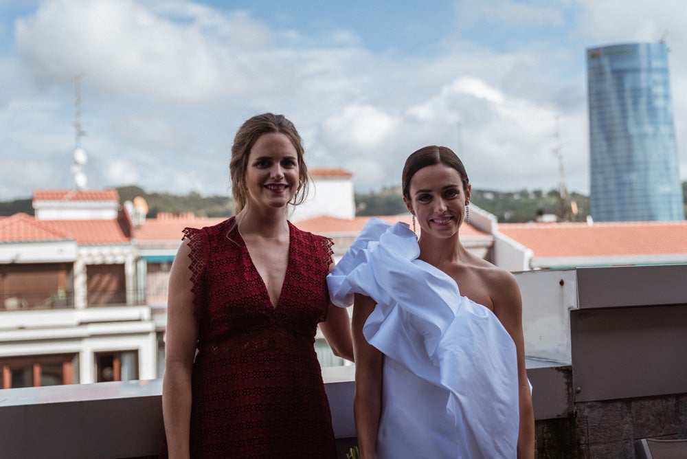 María y Jorge se casaron en Gorliz en una ceremonia íntima adaptada a las circunstancias. De largura 'mini' por encima de la rodilla, con corte asímetrico, volumen en la parte superior y lazadas laterales, la protagonista se ha convertido en una de las novias más impresionantes de las últimas semanas. El diseño lo ha firmado Fabio Encinar, uno de los diseñadores con sede en Madrid más de moda. En cuanto al peinado, otro de los elementos más destacados del estilismo, ha optado por un acertado moño bajo de bailarina súper pulido y tirante, con horquillas de Oui Novias