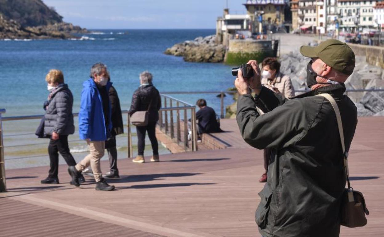 Un hombre saca una fotografía a la bahía de La Concha. 