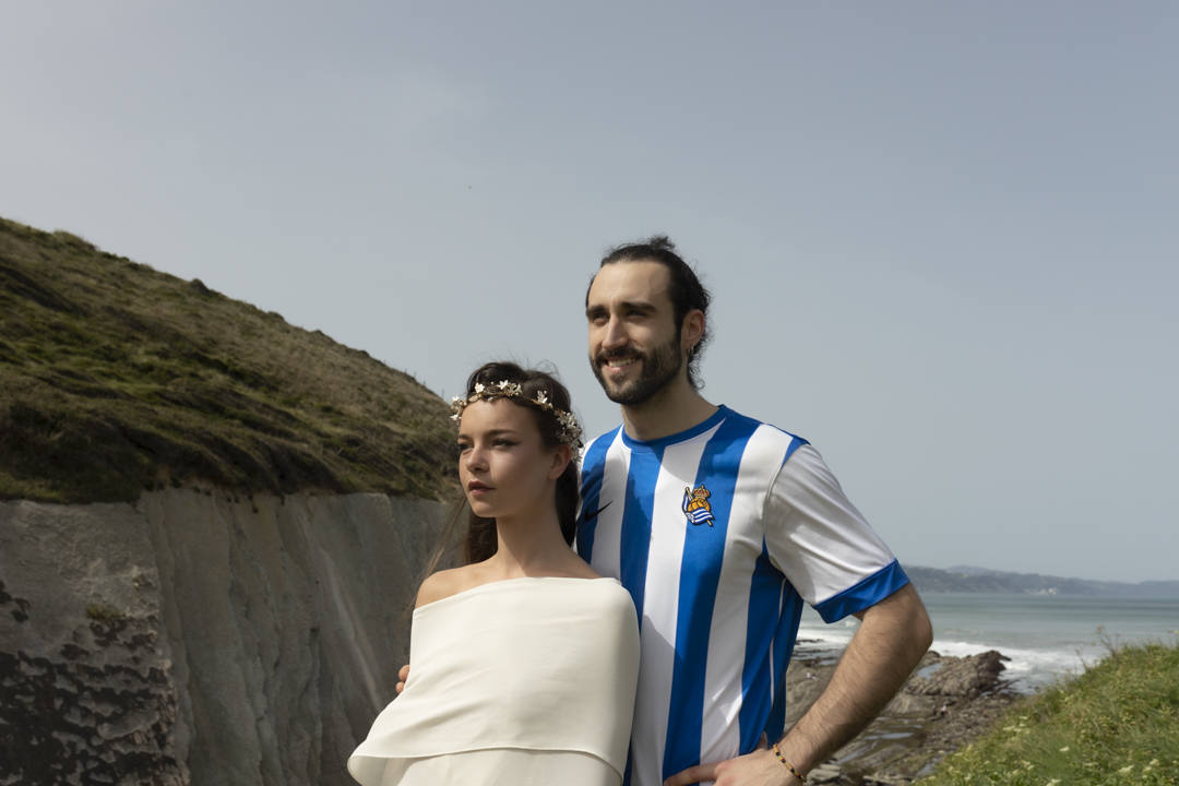Entre rocas, salitre y verdes prados, con el Flysch de Zumaia de fondo y el viento moviendo el tul de seda y las flores de plumas, se encontraban las marcas guipuzcoanas Tocados OH, Irati Guarretxena-Letitare, Inma_Lo y el resto de colaboradores. Mientras trajaban para presentar mediante una sesión de fotos la nueva colección para novia e invitada, aficionados de la Real Sociedad y del Athletic se colaban en el escenario y en el propio 'shooting'. He aquí algunos momentos curiosos de una sesión de fotos marcada por la «fiebre» futbolera