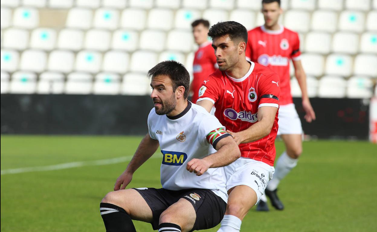 El capitán unionista, Jorge Galán, lucha con un rival por ganar la posición.