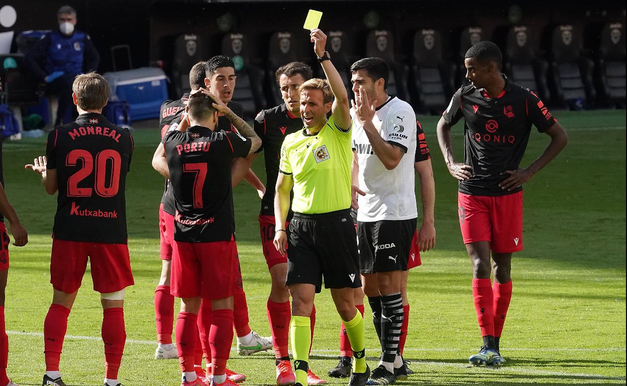 Portu se lleva las manos a la cabeza mientras Pizarro Gómez le muestra la tarjeta amarilla..